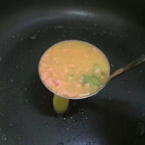 开小火锅内刷一层薄薄的玉米油
锅中放入一小勺鸡蛋火腿液，小火慢慢煎