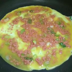 再加入半勺转动锅让鸡蛋液慢慢的流动成圆形，薄厚适中受热均匀