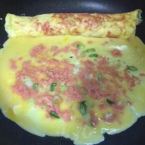 把卷好的第一层放在锅边，剩下的鸡蛋液倒入锅中，继续重复第一层的步骤，转动锅成圆形受热均匀