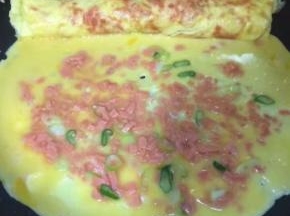 把卷好的第一层放在锅边，剩下的鸡蛋液倒入锅中，继续重复第一层的步骤，转动锅成圆形受热均匀
