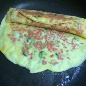 第二层煎至9.5分熟时，从卷好的第一层蛋卷开始向另一头卷起