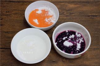 将豆浆机里的玉米胡萝卜糊倒出，同时备好清水和蓝莓汁、糯米粉和粘米粉混合好，三种颜色的碗里倒入等量的米粉；