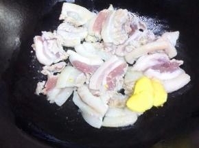 锅中放少许植物油，油五成热时，放入五花肉、姜片煸炒