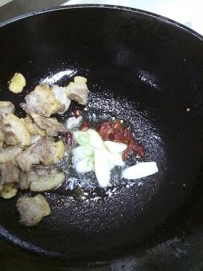 一直煸炒至五花肉变成金黄色，多出的油另外盛出来，放入葱花、干辣椒，炒出香味