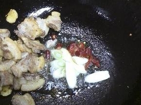 一直煸炒至五花肉变成金黄色，多出的油另外盛出来，放入葱花、干辣椒，炒出香味