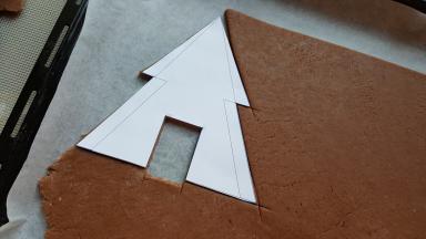 7．把姜饼屋图纸样片放在面片上，用刀刻出饼屋配件。