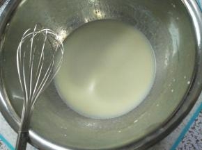 取另外一个大盆，倒入牛奶与色拉油，用手打蛋器搅拌均匀，乳化