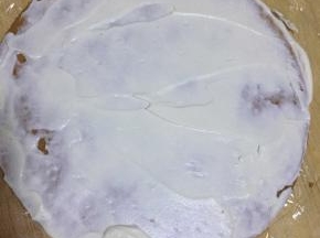 案板或者裱花台上铺一张保鲜膜，大一点拆。然后准备第一张饼铺好，抹一层淡奶油