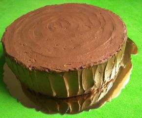 把巧克力甘那许抺在蛋糕上，周围用勺子从下往上轻刮上来，凹凸不平更像树桩，蛋糕面也用勺子划圆圈，划出年轮状