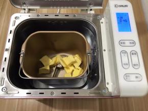 把黄油切好放进面包机桶内，启动翻炒干果功能