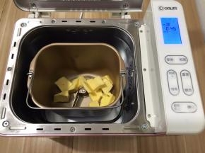 把黄油切好放进面包机桶内，启动翻炒干果功能