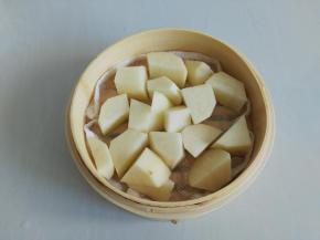 把切好的土豆放入蒸笼的底层，铺满