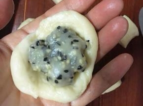 把剂子压扁，包入大概15克左右的馅料