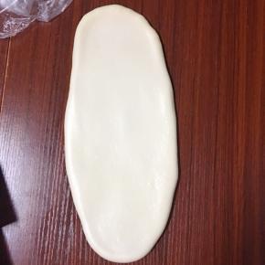 然后用擀面杖慢慢擀成椭圆形
