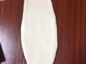 然后用擀面杖慢慢擀成椭圆形