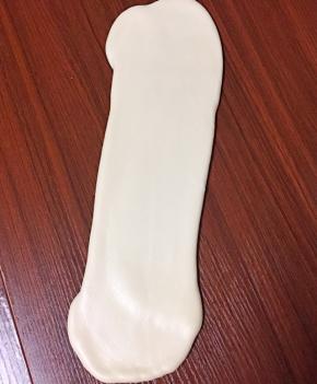 把对折松弛好的面团继续用擀面棍擀成长条状