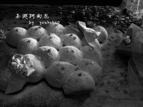 面包放至手温时，表面撒糖粉、糖粒装饰即成