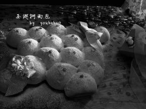 面包放至手温时，表面撒糖粉、糖粒装饰即成