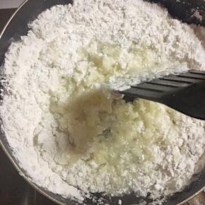 然后倒入糯米粉和熟芝麻快速搅拌均匀。然后关火放凉备