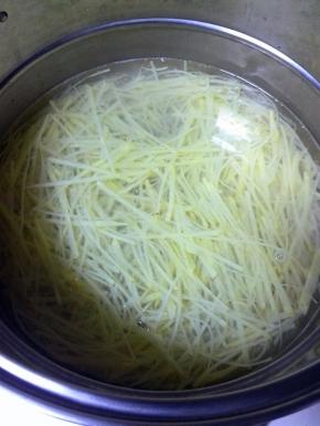 锅中放水、少许的盐，水开后分别放入土豆丝、胡萝卜丝、尖椒圈焯水，断生后捞出