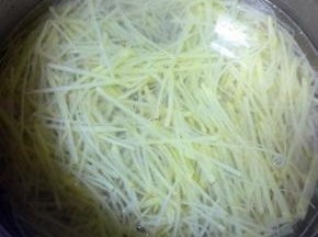 锅中放水、少许的盐，水开后分别放入土豆丝、胡萝卜丝、尖椒圈焯水，断生后捞出