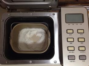 面包桶加入除黄油以外的原料（液体在下，顶部放入高粉和酵母），放入面包机启动和面程序30分钟