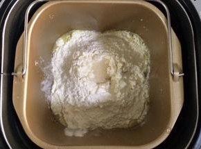 除黄油以外的面包材料都放入面包机内（先液体后粉类的顺序），在面粉中间挖个洞，把酵母粉倒入，启动和面程序。