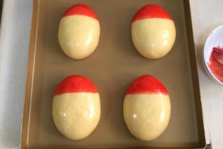 然后取少许红色色素，刷在面团的一头，做帽子部分。（我这里用的是液体的色素，非液体的可以滴几滴水化开后刷）