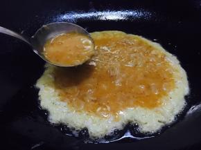 锅热后放入适量的油，当油温4成热时放入一半的鲜虾皮鸡蛋液，然后改成中小火煎制。