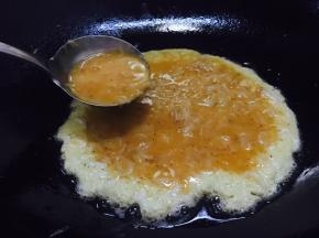 锅热后放入适量的油，当油温4成热时放入一半的鲜虾皮鸡蛋液，然后改成中小火煎制。