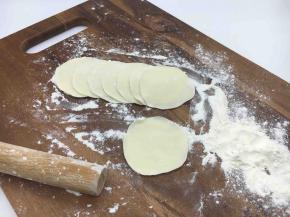 把小圆剂子压平，擀成饺子皮，擀饺子要中间厚边薄。