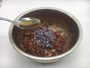 最后放入洋葱碎，在洋葱碎上放约20g左右的香油，先用香油把洋葱碎拌匀，再将洋葱碎与肉馅充分调匀，继续朝一个方向搅拌均匀，大约搅拌100下左右。 先用油裹住洋葱碎的目的是防止葱汁外溢，造成肉馅葱味过重。