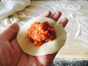 往饺子皮上放适量的饺子馅。