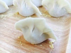 小饺子包好了，虽然没有漂亮的褶，但是很实惠，是个大肚子小饺子，薄皮大馅哦。
把包好的饺子整齐的码放在饺子板上。 饺子板上要提前均匀地撒些面粉，避免饺子和饺子板粘连。