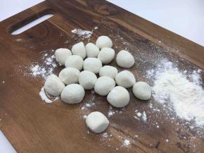 拿出面团再把它们揉匀，取一块小块面团（其它的放回盆里保存），把它用双手搓成长条，再揪成小圆剂子。