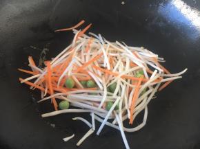 用煎鸡蛋饼的底油，煸炒一下豌豆、胡萝卜、绿豆芽，使其断生。
