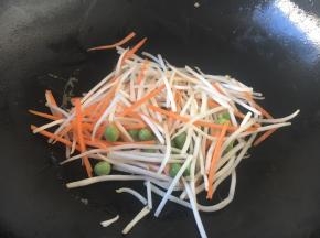 用煎鸡蛋饼的底油，煸炒一下豌豆、胡萝卜、绿豆芽，使其断生。