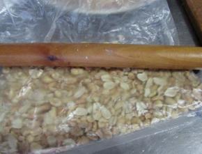 熟花生米用保鲜袋装着擀压成碎粒