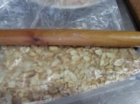 熟花生米用保鲜袋装着擀压成碎粒