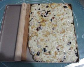 放入不沾烤盘中在，用擀面杖擀压平整，然后表面撒上奶粉，做出雪花。稍微晾凉后翻面，也撒上奶粉