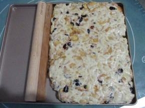放入不沾烤盘中在，用擀面杖擀压平整，然后表面撒上奶粉，做出雪花。稍微晾凉后翻面，也撒上奶粉