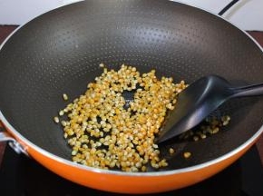 关火，把玉米粒倒入，均衡裹上黄油；