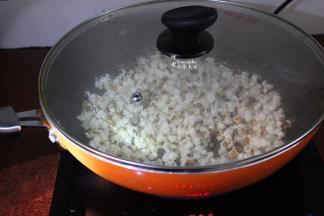 等玉米粒迅速爆开的时候，翻动几下锅，不要开盖，让玉米粒均衡爆开；