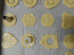 小心取出摆入烤盘，用小一号的模具按压在饼干中间，然后小心取出（取出的面团再混合擀开重复即可）