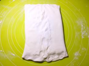 将两侧的面片掀起，包裹上黄油，捏紧收口