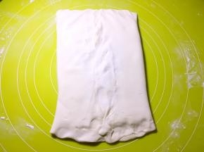 将两侧的面片掀起，包裹上黄油，捏紧收口