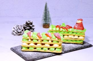 最后再将另外一片酥皮放上，挤上奶油霜，用草莓装点一下，最后撒点糖霜即可