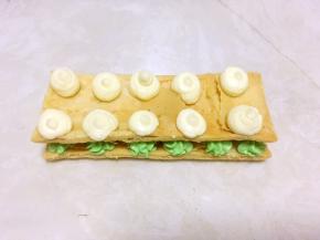 盖上另外一份酥皮，再在上面挤上白色的奶油霜