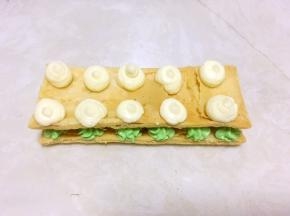 盖上另外一份酥皮，再在上面挤上白色的奶油霜