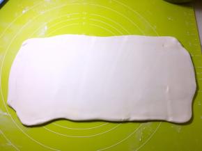 将对折好的面片再次擀成长方形，可以撒点干粉，这样更好擀